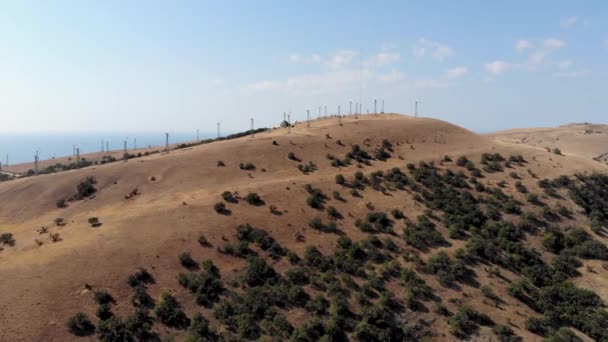 Εναέρια πτήση προς τους ανεμόμυλους που στέκονται στην κορυφή του βουνού. Που λαμβάνονται από drone — Αρχείο Βίντεο
