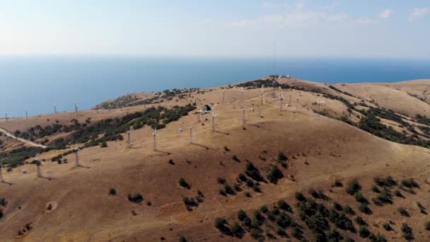 Vuelo aéreo a los molinos de viento de pie en la cima de la montaña. Tomado por dron — Vídeos de Stock