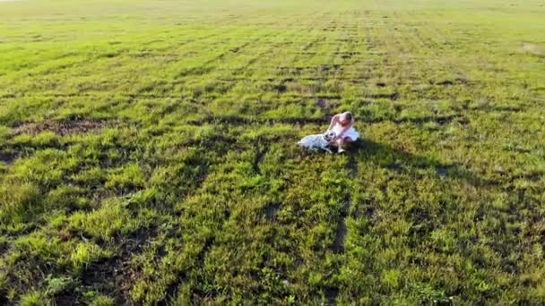 아름다운 소녀가 쉬면서 달마티아 개와 놀고 있습니다. Taken by drone — 비디오