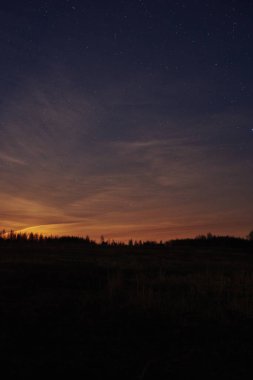 Gökyüzü yıldızlı gölde alacakaranlıkta gün batımında.