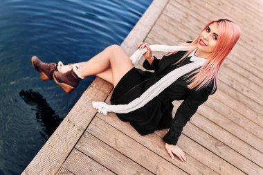 Pembe saçlı kız sonbahar parkında yürüyor.