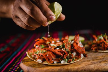 Meksika taco 'suna sıkılmış bir limonu yakın plan, geleneksel renkli arka plan.