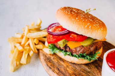 Beyaz arka planda büyük bir burgerin üst görüntüsü. Amerika Birleşik Devletleri 'nin tipik mutfağı, fast food' u temsil ediyor.