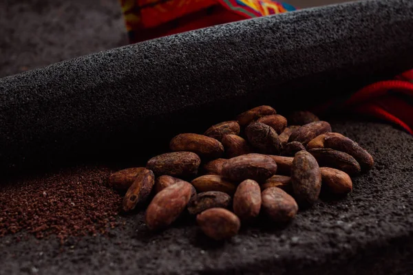 Side view of cocoa and cacao powder on a traditional metate, used in Mexican indigenous culture to extract the powder from the cacao beans or cacao nibs