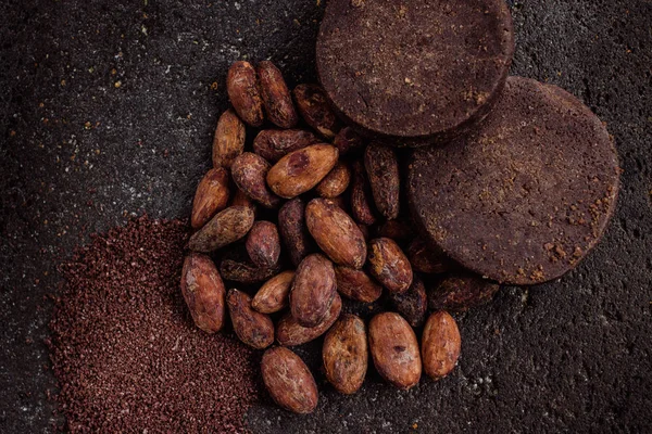 Mexican chocolate, cacao powder and cocoa top view, on a traditional metate. Cacao beans or cacao nibs are traditionally roasted in Oaxaca.