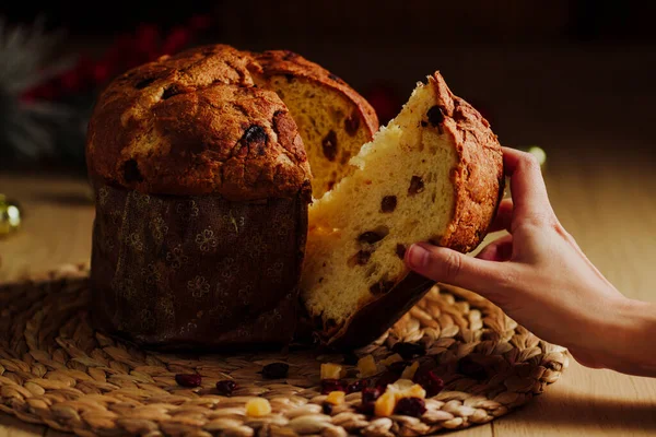 Kadın eli Panettone 'dan bir parça alıyor.