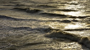 Gün batımında deniz dalgaları. Yaz güneşli arka plan.