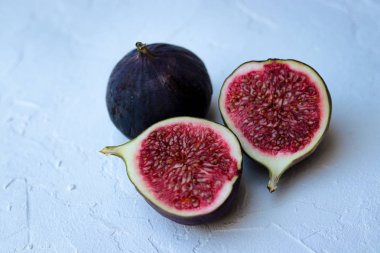 Beyaz arka planda dilimlenmiş taze incirler.