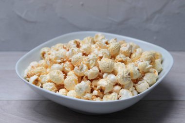 Beyaz ahşap bir masada kasede patlamış mısır.