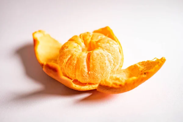 Mandarino succoso luminoso sotto forma di un fiore isolato su uno sfondo bianco. Scorza di mandarino sotto forma di petali — Foto Stock