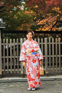 Asyalı güzel bir kadın kimono giyip Japonya 'nın Kyoto kentindeki eski Japon evini geziyor.