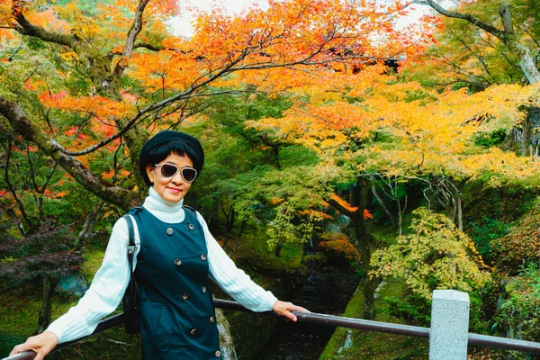 在秋天的季节里 亚洲女游客对着有秋天花园背景的相机 摆出一副笑脸 — 图库照片