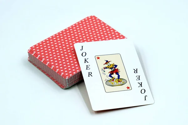 Game card Joker against a set of playing cards.