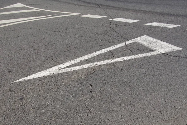 Road marking on cracked asphalt.