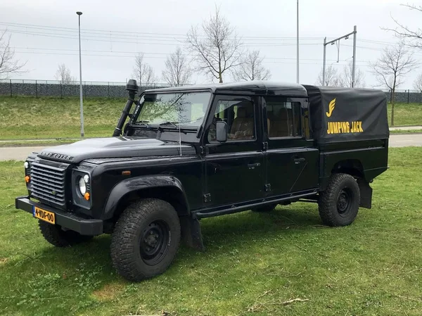 Almere, the Netherlands - March 23, 2018: Black Land Rover Defender 130 Craw Cab parked by the side of the road. Nobody in the vehicle.