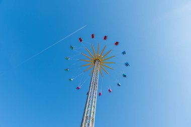 boğaz mavi gökyüzü ve uçak hattı karşı yüksek uçan atlıkarınca bir