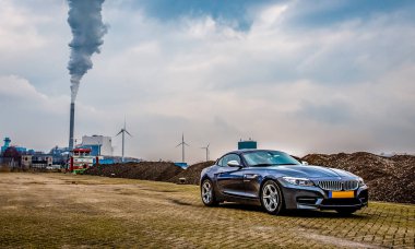 Gemiler ve endüstriyel baca ile Amsterdam limanında Gri Bmw Z4 düşük açılı resim