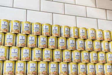 Beyaz kiremitli bir duvara yaslanmış zeytin tenekeleri yığını