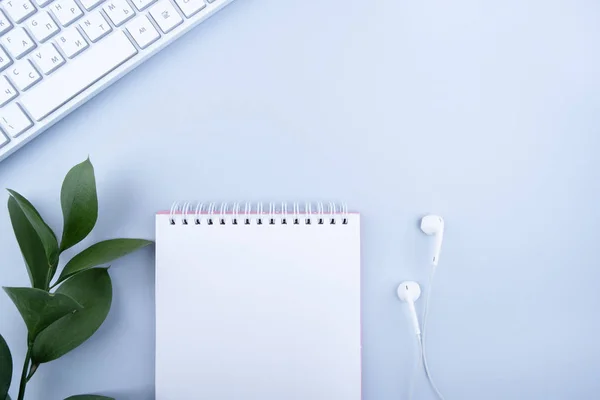 Not defteri, bilgisayar ve kulaklıklı ofis masası. Kopyalama alanı olan üst görünüm.