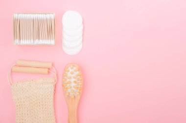 Eko temalı, pembe arka planda vücut bakım ürünleri bambu kulak çubukları, bez ve masaj anti-selülit fırçası..