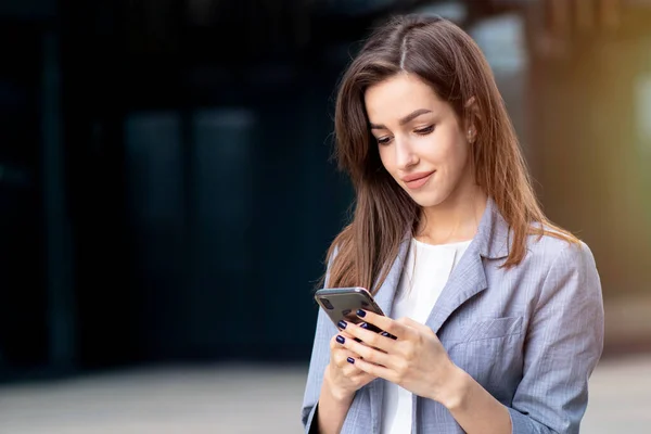 Mesaj yazan Avrupalı bir kadın, SMS mesajı yolluyor, cep telefonuna SMS gönderiyor. Gözlüklü genç iş adamı, iş kadını cep telefonuna bakıyor. 