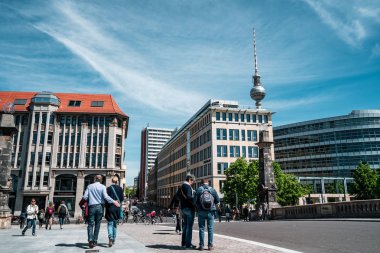 Berlin, Almanya - 12 Mayıs 2019: Berlin Tv Kulesi, sokakta dolaşan insanların şehri binaları arasında.