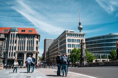 Berlin, Almanya - 12 Mayıs 2019: Berlin Tv Kulesi, sokakta dolaşan insanların şehri binaları arasında.
