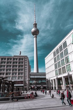 Berlin, Almanya - 12 Mayıs 2019: Sokak binaları ve bulutlu gökyüzü arasında Berlin Tv Kulesi.