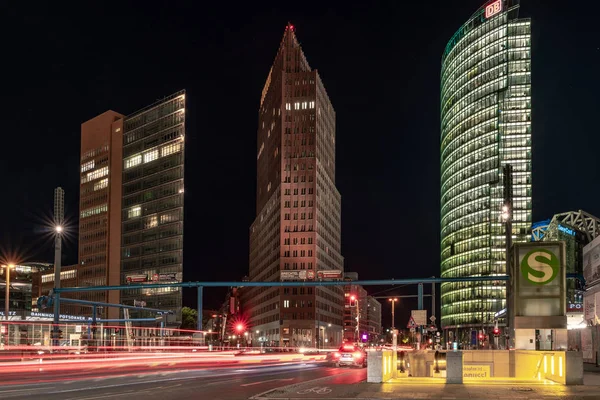Berlin, Almanya - 12 Mayıs 2019: Potsdamer Platz'ın gün batımında araba ışıkları ve toplu taşıma araçlarıyla binaları.