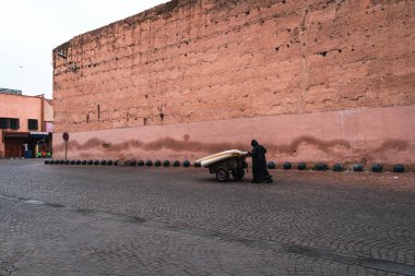 Marakeş, Fas - 07 Mart 2019. Marakeş 'teki Yahudi mahallesinde, bir adam içinde mal olan bir el arabası taşıyor.