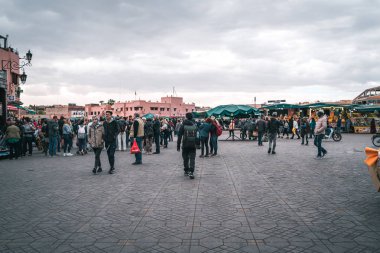 İnsanlar Marakeş, Fas 'ın ana meydanı Jamaa el Fna' yı ziyaret ediyor.