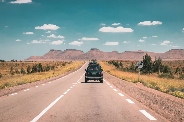 在乡间空旷的柏油路上 丰田汽车行驶在通往沙漠的路上 — 图库照片