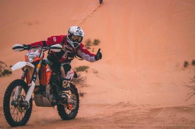 Sahra Çölü, Tunus - 6 Kasım 2014. Sahra Çölü 'nde inanılmaz maceralı bir yolculukta Enduro motosikleti süren adam.