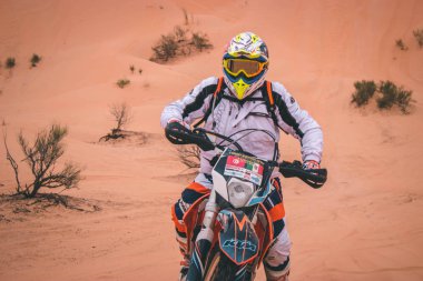 Sahra Çölü, Tunus - 6 Kasım 2014. Sahra Çölü 'nde inanılmaz maceralı bir yolculukta Enduro motosikleti süren adam.