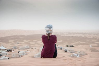 Çöldeki kız, sonsuz kum tepelerine bakıyor.