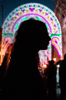 Gecenin içindeki kız, şehrin ışığı bulanık.