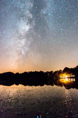 Yansıması ve yıldızları olan sütlü bir manzara.