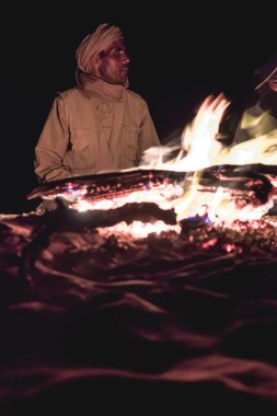 Sahra Çölü 'ndeki Şenlik Ateşi' nin önündeki Bedevi adam.
