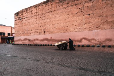 Marakeş, Fas caddesinde yürüyen siyah elbiseli adam.
