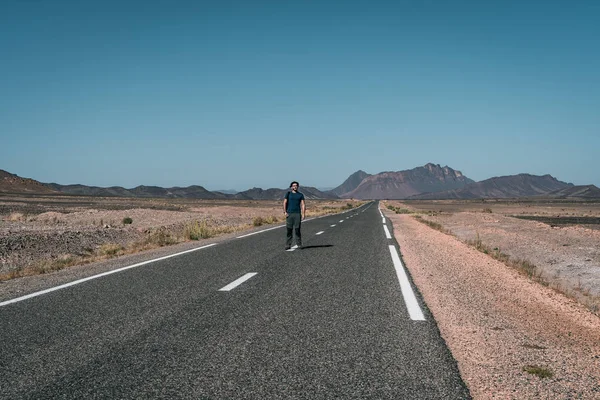 一个人在沙漠中摆出一张照片 一条空荡荡的柏油路 — 图库照片