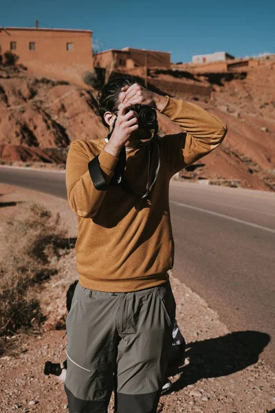 穿着黄色毛衣的男人在山上拍照 — 图库照片