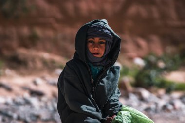 Fas 'ta siyah giyinmiş berber bir çocuk oturuyor.