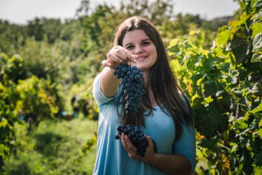 Olgun üzümlü genç ve güzel bir kadın.