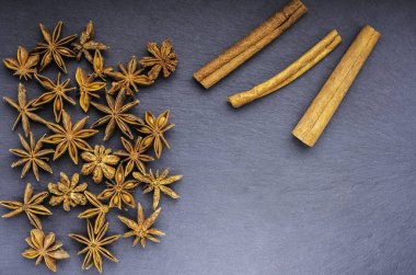 Yıldız anason ve tarçın kayrak üstten görünüm üzerinde dağınık.