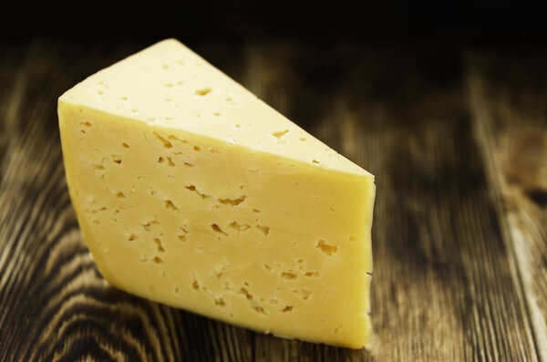 Cave matured with ash, pecorino cheese on wooden block, background