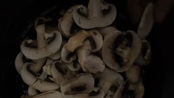 Roosteren knoflook en champignon champignons op een oude gietijzeren pan — Stockvideo