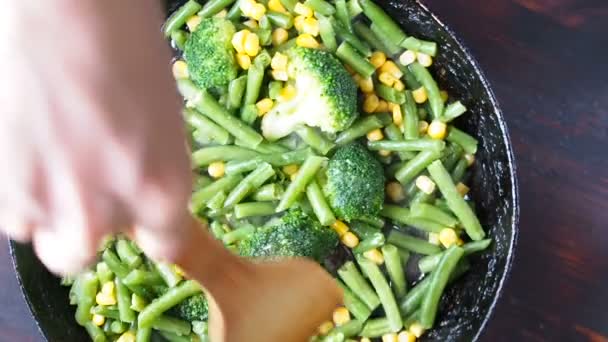 Asar brócoli a la parrilla en una sartén de hierro fundido con frijoles y maíz. cámara lenta — Vídeo de stock
