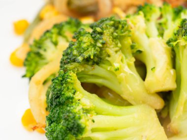 pişmiş sebze brokoli, havuç, yeşil fasulye, Mısır beyaz tabakta. Makro