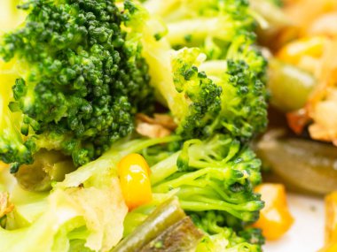 pişmiş sebze brokoli, havuç, yeşil fasulye, Mısır beyaz tabakta. Makro