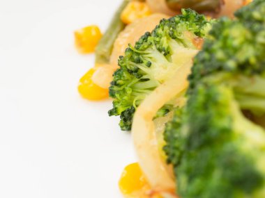 pişmiş sebze brokoli, havuç, yeşil fasulye, Mısır beyaz tabakta. Makro